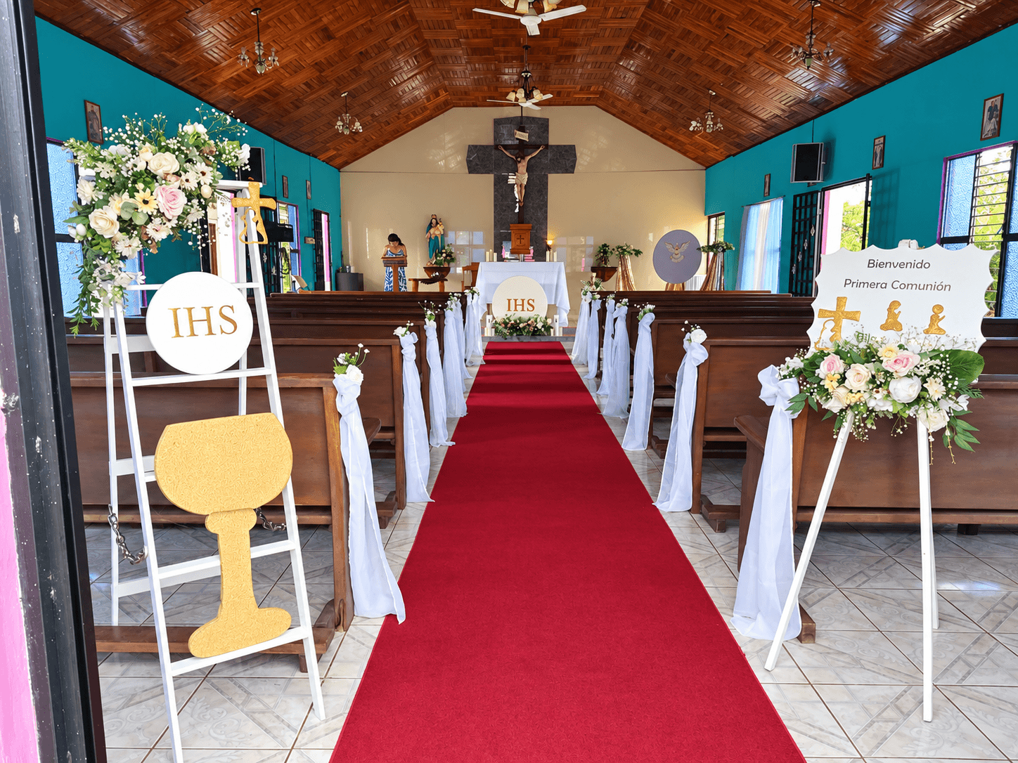 Pasillo de iglesia decorado con flores blancas y rosadas para primera comunión