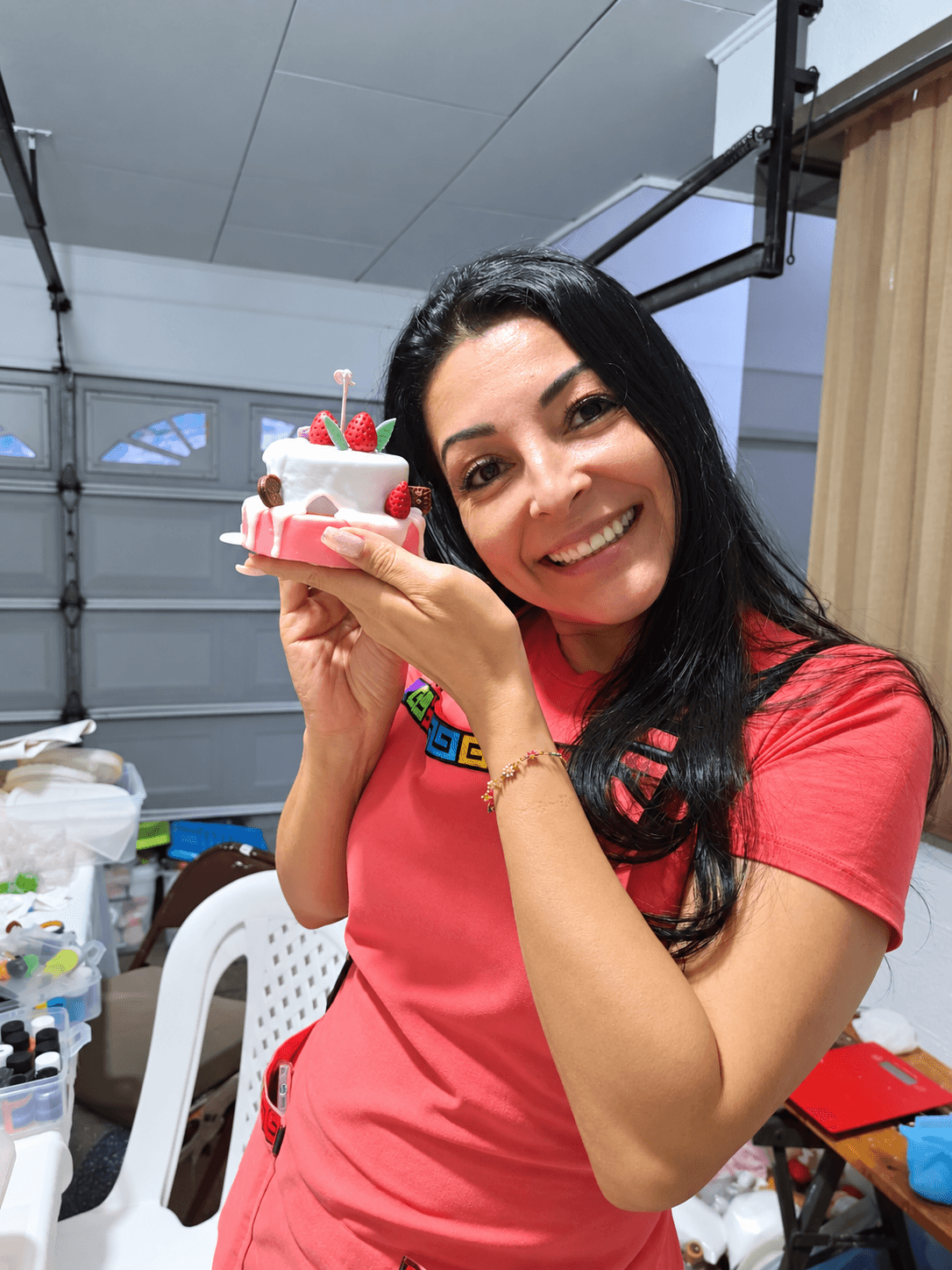 Participante mostrando su creación decorativa en forma de pastel